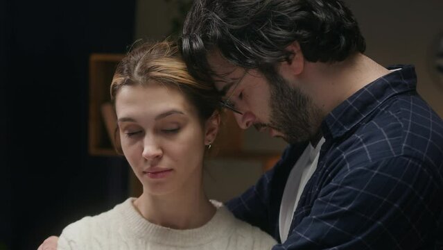 Man and offended woman reconciling, wife forgiving husband. Young couple hugging after conflict. Family problems, crisis in relationships. 