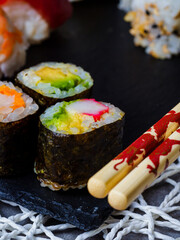 close-up of three pieces of sushi, dark background 
