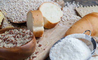 wheat baguette on the table with flour and various plant grains