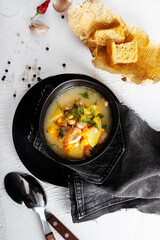Pea soup with bacon and parsley in a bowl on a white background. Selective focus