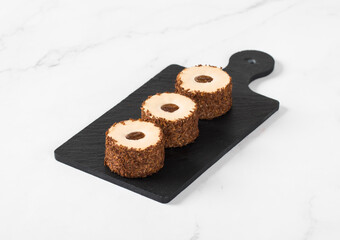 Coffee sweet round sushi on a serving board. Light background