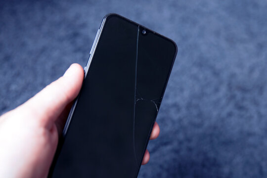 phone with broken screen in hand
