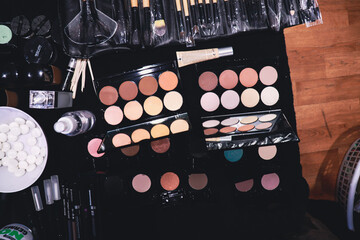 flat lay of colourful eye shadow and make up palettes with application brushes for makeup artist