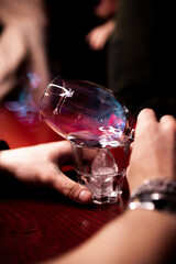 The bartender makes cocktails in a nightclub. Burning absinthe in a glass mug. Fire in a glass