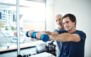 Hold for a few more seconds.... Shot of a physiotherapist helping a patient work through his recovery with weights.