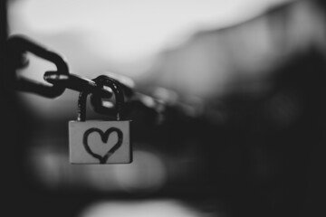 Selective focus grayscale shot of a lock with a heart on it - love concept