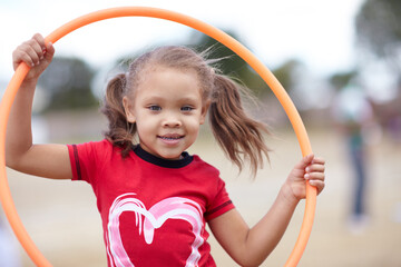 Little miss hula hoop. Cute little preschooler playing with a hula hoop while outdoors.