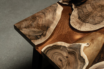 Fototapeta na wymiar Expensive vintage furniture. The table is covered with epoxy resin and varnished. Luxury quality wood processing. Wooden table on a dark background. A gold epoxy river in a rectangular tree slab.