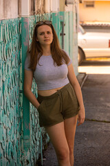 Fototapeta premium Young woman relaxes while leaning against a wall - photo shoot on the Florida Keys