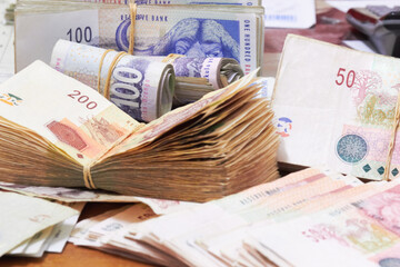 The monthly profit. Large piles of money and loose bills on the table.