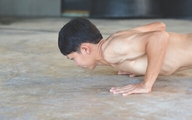 Young Asian men are exercising by doing push-up moves to build healthy and healthy muscles.