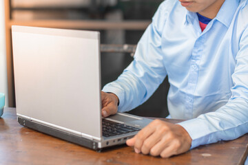 Young man working on a laptop at home, Technology & Business Concepts.