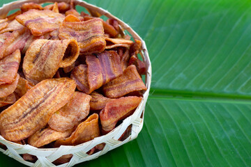 Banana slice chips in bamboo basket on banana leaf