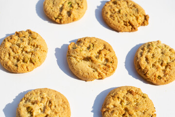 Pistachio and almond cookies on white background.