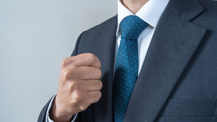 拳を握るスーツ姿の男性｜やる気を出す