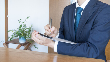 メモを取る男性・個人宅へ訪問営業イメージ