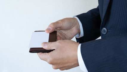 名刺・ビジネスカードを交換する男性。	