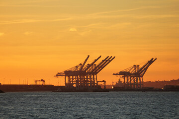 Fototapeta na wymiar Senset over Long Beach loading docks with cranes