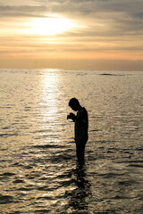 A silhouette of kids with sunset as background