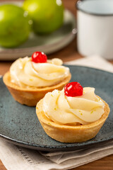 Lemon tartlets decorated with cherry.