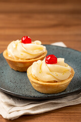 Lemon tartlets decorated with cherry.