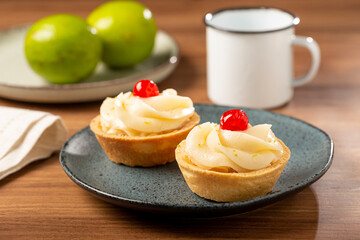 Lemon tartlets decorated with cherry.