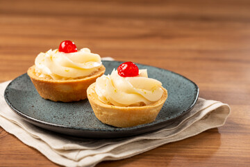 Lemon tartlets decorated with cherry.