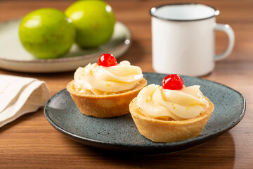 Lemon tartlets decorated with cherry.