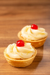 Lemon tartlets decorated with cherry.
