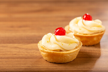 Lemon tartlets decorated with cherry.