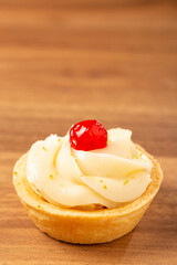 Lemon tartlets decorated with cherry.