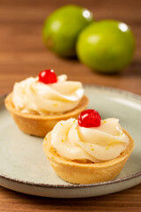 Lemon tartlets decorated with cherry.