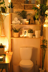 Stylish bathroom interior with toilet bowl and green plants