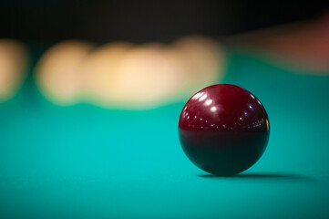 a billiard ball is lying on a table with a blurry background