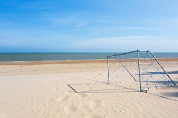 Beach football goal under blue sky ,Goal football or soccer on the beach with nest and blue sky with beautiful cloud in a sunny day. sport on the beach or goal and success concept