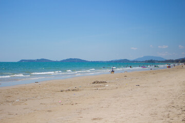 Fototapeta na wymiar Blue sea on the beach covered with fine sand with bright blue sky in Thailand.