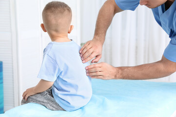 Fototapeta premium Orthopedist examining child's back in clinic, closeup. Scoliosis treatment