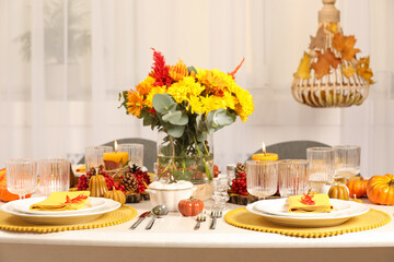 Autumn table setting with floral decor and pumpkins indoors