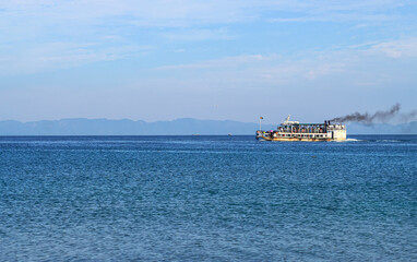 Small tourist ship with passengers. Beautiful seascape with a tourist boat. The ferry just left the pier.