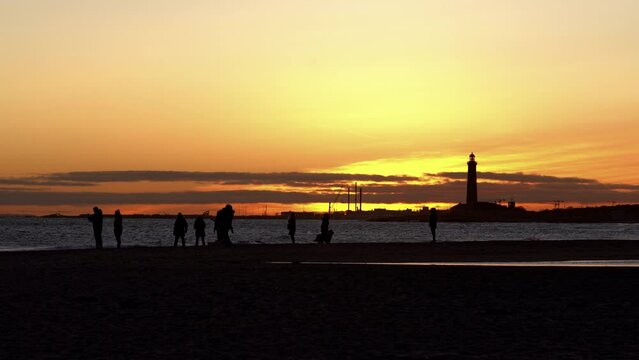 People Walking Along Grenen Sandbar At Sunset