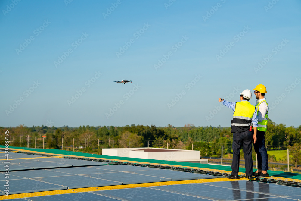 Wall mural professional engineer using drone and digital tablet maintaining solar cell panels together on build