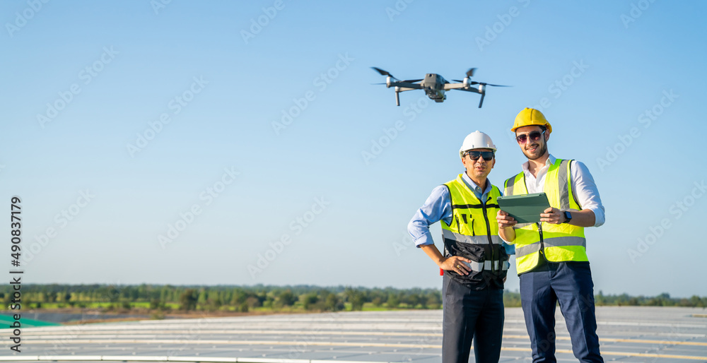 Wall mural professional engineer using drone and digital tablet maintaining solar cell panels together on build