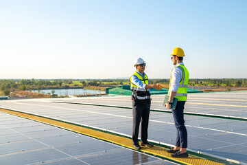 Fototapeta premium Professional engineer using drone and digital tablet maintaining solar cell panels together on building rooftop. Technician working on ecological solar farm. Renewable clean energy technology concept