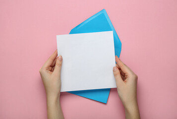 Woman holding blank letter on pink background, top view