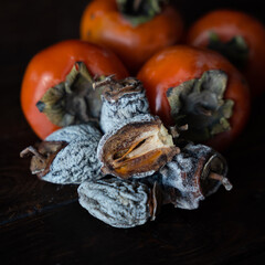 Dried persimmon and fresh persimmon on a wooden background. Healthy diet. Healthy diet