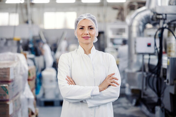 Portrait of successful food factory worker smiling at the camera.
