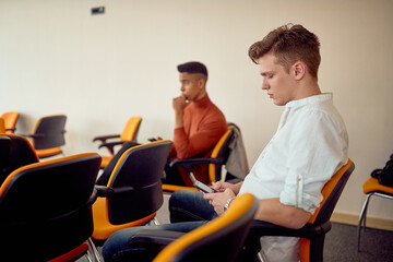 Young participants are bored during a business lecture in the conference room. Business, people,...