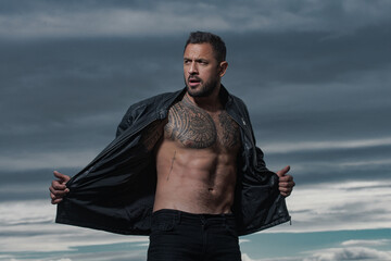 Fashion male model with leather jacket. Confident attractive man with serious face.