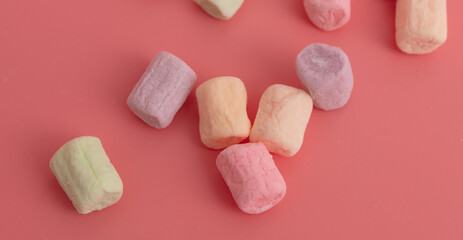 Multicolored candies on a pink background. Close-up