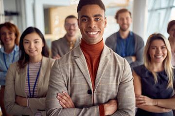 Obraz premium Close-up shot of a young cheerful businessman standing in the company building hallway with his colleagues and enjoys posing for a photo. Business, people, company